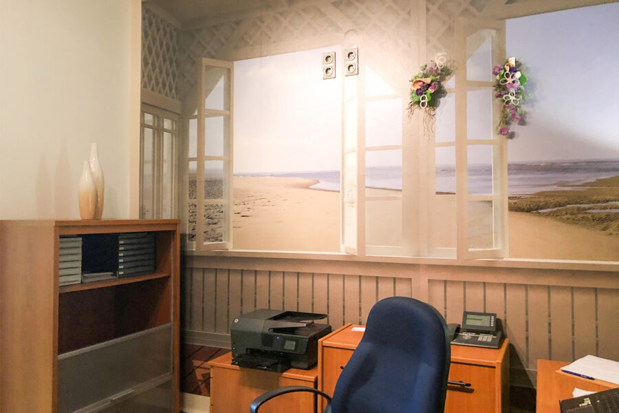 Beratungszimmer mit gemütlicher Atmosphäre und Wandbild einer Strandlandschaft