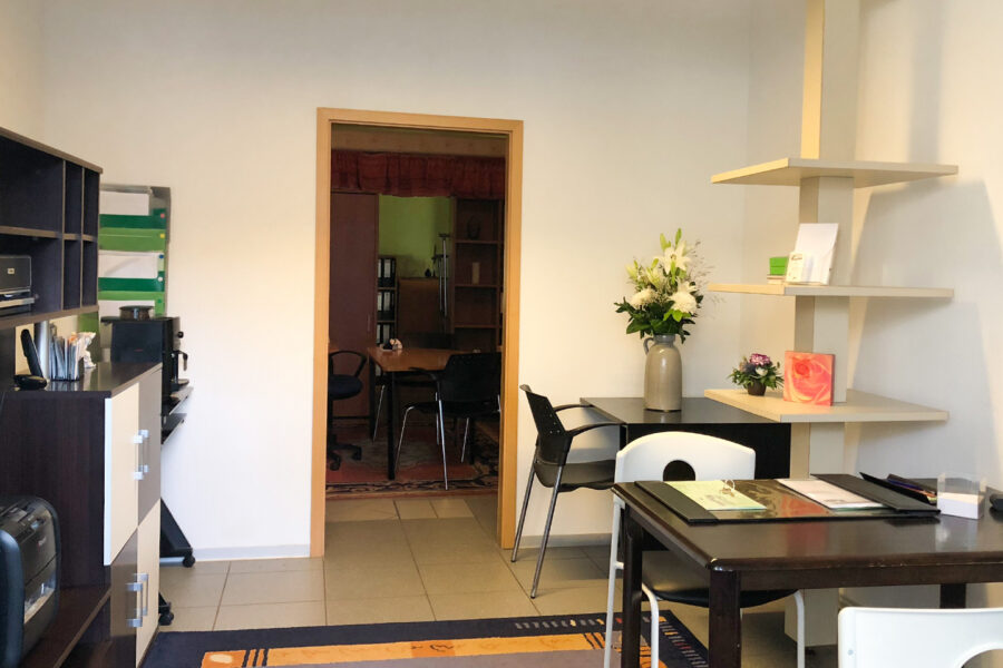 Moderner Besprechungsraum mit Blumen und Regalen für Bestattungsvorsorge